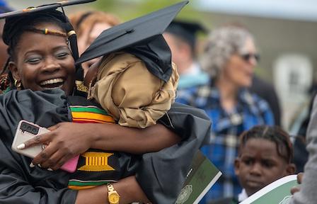 刚毕业的学生在毕业典礼上拥抱他们的支持者